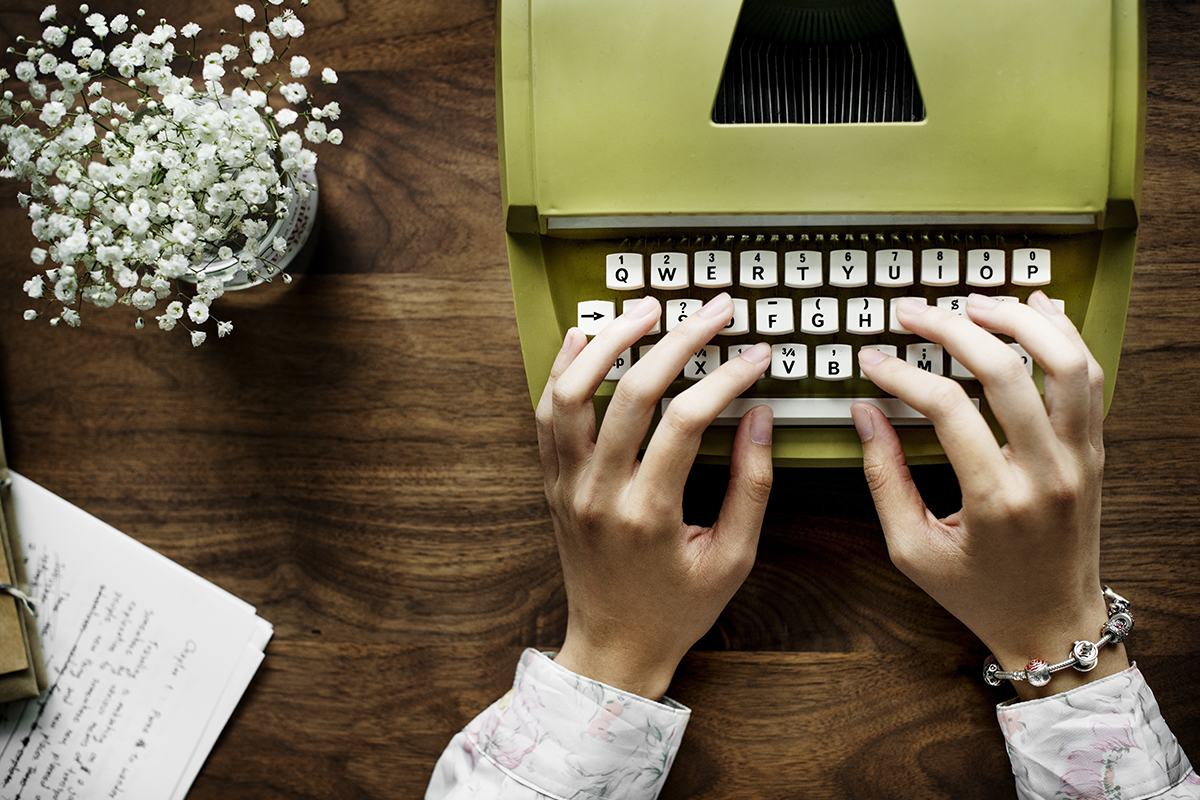 Aerial view a woman using a retro typewriter